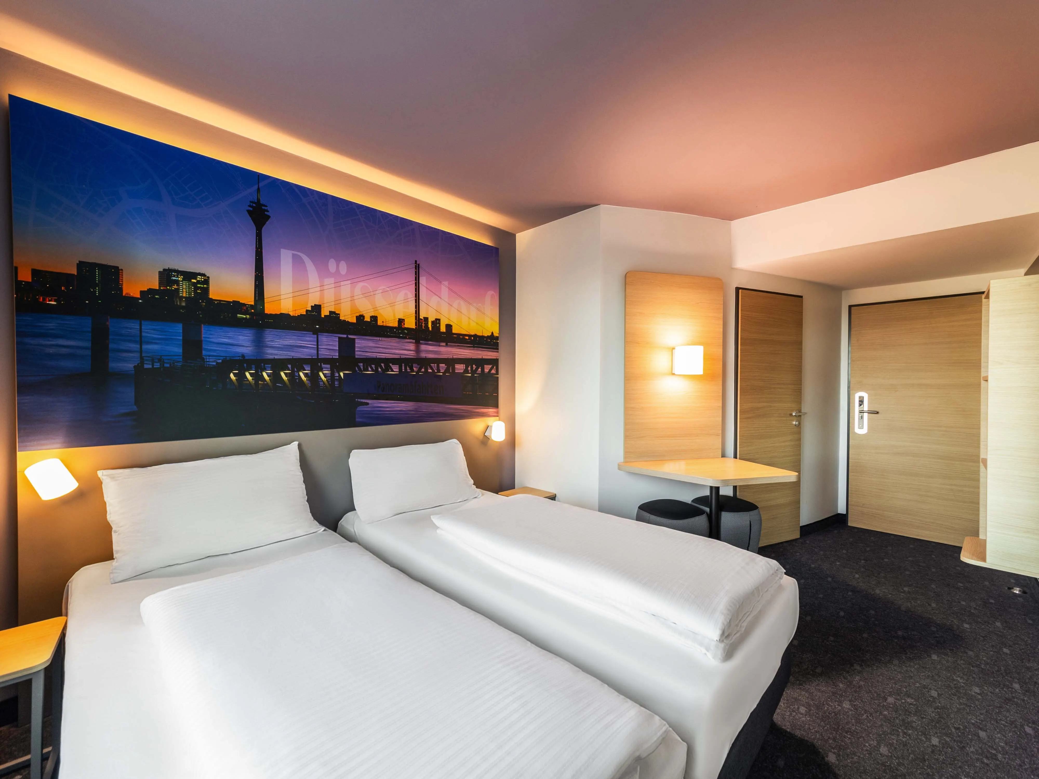 Pokój B&B Hotels z dużym plakatem miasta i zabudową meblową