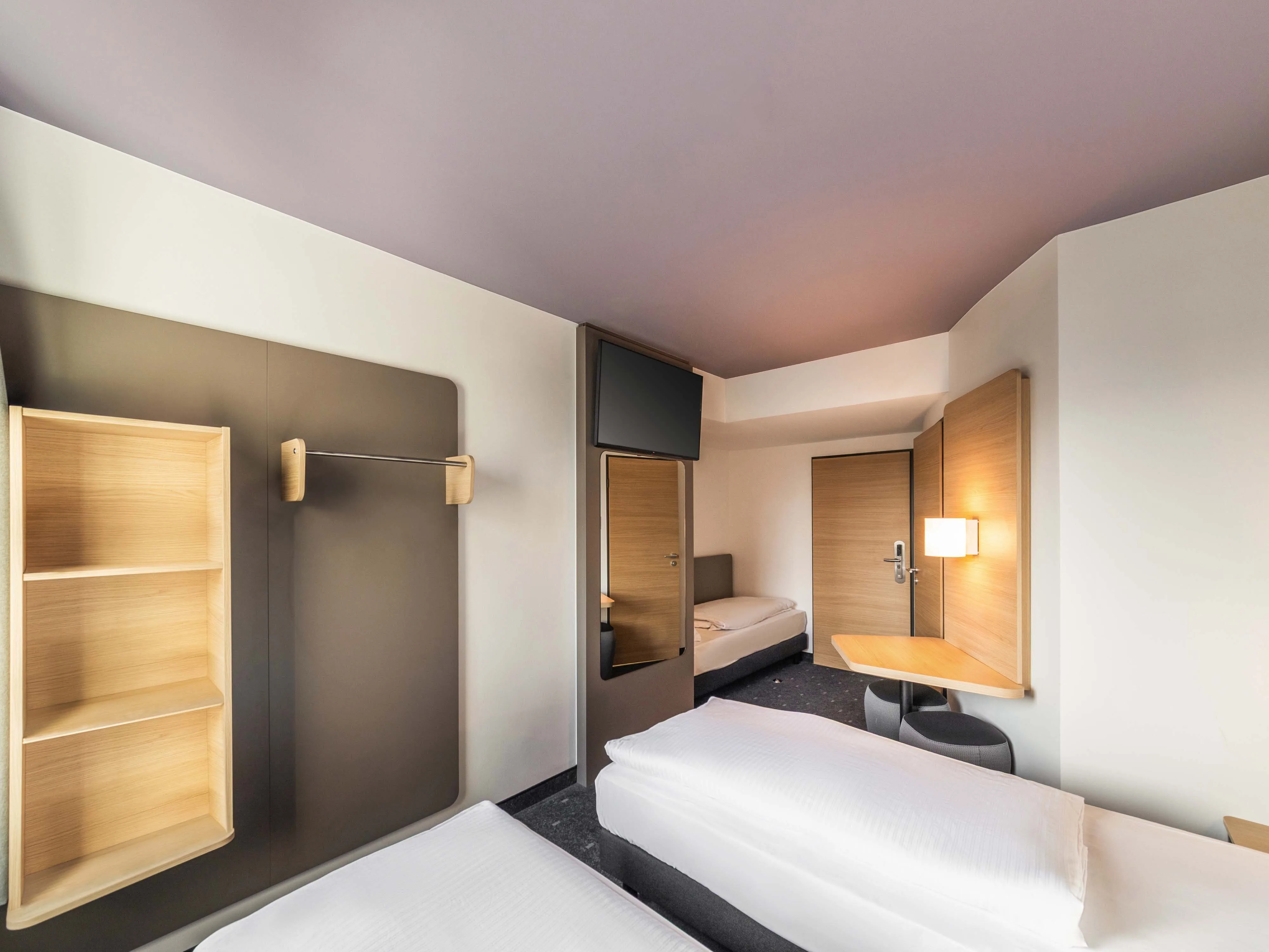 Pokój B&B Hotels z otwartą półką, panelem ściennym i biurkiem